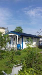 una piccola casa bianca con tetto blu di Gäststuga a Falkenberg