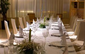 a long table with white plates and wine glasses at Hotel San Antonio in Albacete