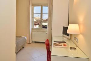 a room with a desk with a television and a bed at Residenza Fiorentina in Florence