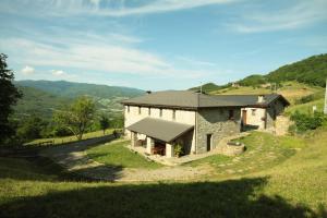una casa de piedra al lado de una colina en Agriturismo Le Querciole, en Borgo Val di Taro