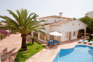 uma villa com uma piscina e uma palmeira em Villa Sa Coma em Sa Coma