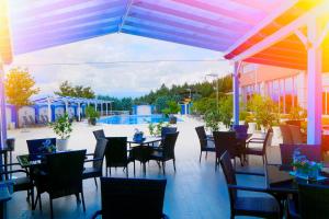 a restaurant with tables and chairs on a patio at Ramada Plaza by Wyndham Gevgelija in Gevgelija