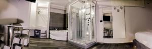 een badkamer met een glazen douche en een bad bij Hotel Pandora Residence in Tirana