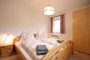 1 dormitorio con cama de madera y almohadas en Almliesl ZELL-374, en Zell am See