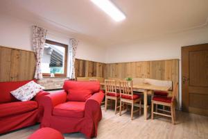 ein Wohnzimmer mit einem roten Sofa und einem Tisch in der Unterkunft Almliesl ZELL-374 in Zell am See