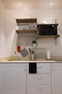 a kitchen counter with a sink and a microwave at Mamilla Design Apartments in Jerusalem