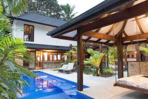 a house with a swimming pool in front of a house at Spice At Oak Absolute Beachfront with Private Pool Near Port Douglas in Oak Beach