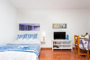 a white bedroom with a bed and a tv at Studio Atlantic View in Icod de los Vinos