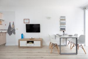 ein Wohnzimmer mit einem Tisch und einem TV an der Wand in der Unterkunft Studio Atlantic View II in Icod de los Vinos