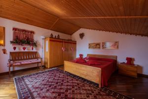 a bedroom with a bed with red sheets and a rug at Ai Due Pini B&B in Pescantina