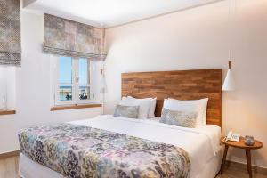 ein Schlafzimmer mit einem großen Bett und einem Fenster in der Unterkunft Avra Apartments Venetian Harbour in Chania