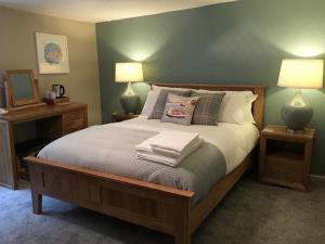 ein Schlafzimmer mit einem Bett mit zwei Lampen und Kissen in der Unterkunft The London Inn in Padstow