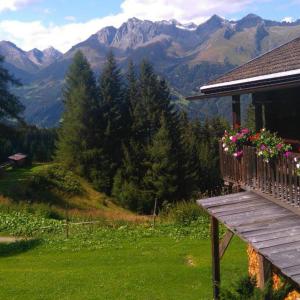 uma varanda com flores ao lado de uma casa em Chalet Rustikal em Virgen