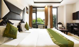 Un dormitorio con una gran cama blanca con una gran ventana. en Hotel Baljeet Lodge, en Nueva Delhi