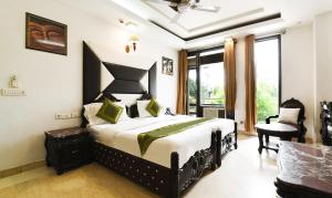 Un dormitorio con una cama tamaño king y una silla. en Hotel Baljeet Lodge, en Nueva Delhi