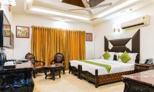 Una habitación de hotel con una cama, un escritorio y sillas. en Hotel Baljeet Lodge, en Nueva Delhi