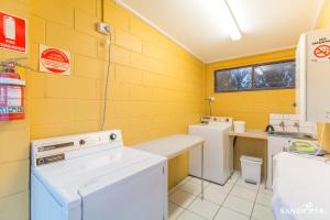 a laundry room with a washer and dryer and a sink at Sandpiper Motel Apollo Bay in Apollo Bay