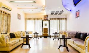 una sala de estar con sofás y mesas. en Hotel Baljeet Lodge, en Nueva Delhi