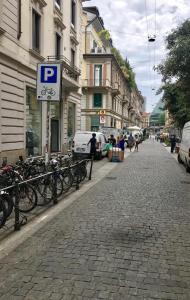 eine Straße mit einem Parkschild auf einem Ziegelsteinweg in der Unterkunft Sarpi Apartment in Mailand