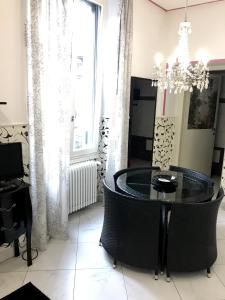 ein Esszimmer mit einem Tisch, Stühlen und einem Kronleuchter in der Unterkunft Sarpi Apartment in Mailand