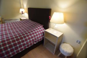 a bedroom with a bed with a lamp and a stool at Arahova Pansion in Arachova