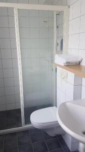 a bathroom with a shower and a toilet and a sink at Glomfjord Hotel in Glomfjord
