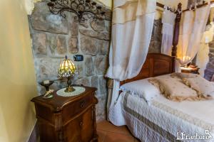 a bedroom with a bed and a stone wall at LT Lanzi - Frantoro in Viterbo