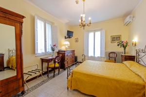 a bedroom with a bed and a dresser and a desk at Albergo Il Marzocco in Montepulciano