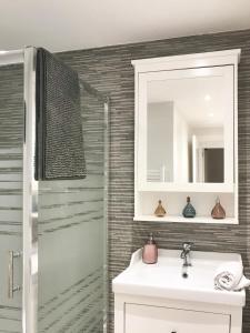 bagno con lavandino, specchio e doccia di Apartamento cerca del mar (parking incluido) a Blanes