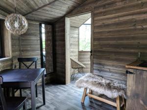 a dining room with wooden walls and a table and chairs at Revontuli Resort Cottages in Hankasalmi