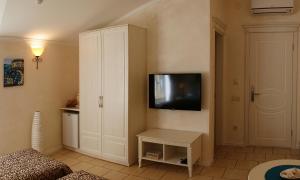 sala de estar con TV y armario blanco en Gomer Hotel (Adults only), en Balaklava