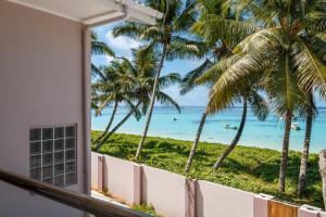 a room with a view of the ocean and palm trees at Shanaz Beachside Retreat in Anse Royale