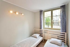 a bedroom with two beds and a window at Apartament Ten in Gdańsk
