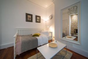 a bedroom with a bed and a mirror and a table at Central London Apartment - Great Location in London