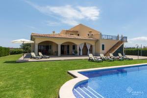 a villa with a swimming pool in front of a house at Mussol in Sa Pobla