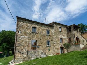 a stone building on a grassy hill with a sky at Pretty Farmhouse with pool in Sestino