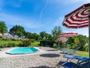 einen Pool mit Sonnenschirm, Stühlen und Sonnenschirm in der Unterkunft Belvilla by OYO La Cinciallegra in Acqualagna