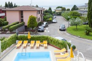 a hotel with a pool and chairs and a parking lot at Hotel GARDENIA & Villa CHARME Adults Friendly 10Plus in Bardolino