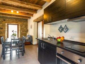 a kitchen with a table and a dining room at Pretty Farmhouse with pool in Sestino