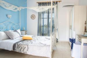 a bedroom with a bed with a blue wall at Aelia Studios in Koukounaries