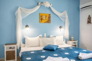 a blue bedroom with a bed with a blue wall at Aelia Studios in Koukounaries