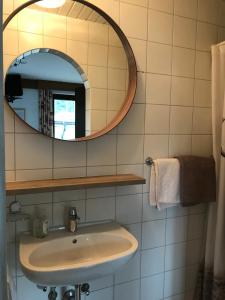 La salle de bains est pourvue d'un lavabo et d'un miroir. dans l'établissement Pension Jaga Hias, à Kaprun