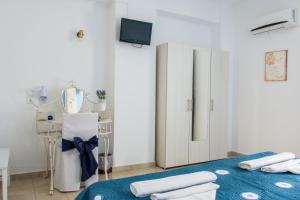 a white room with a bed and a mirror at Aelia Studios in Koukounaries