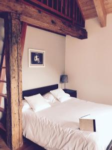 Schlafzimmer mit einem weißen Bett mit Holzbalken in der Unterkunft Agriturismo La Tensa in Domodossola