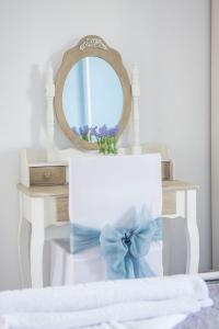 a mirror on a table with a white box with a blue bow at Aelia Studios in Koukounaries