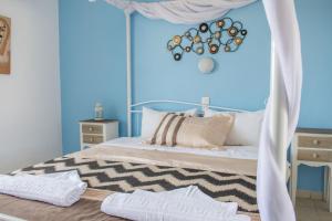 a bedroom with a bed with a blue wall at Aelia Studios in Koukounaries