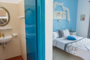 a blue bedroom with a bed and a sink at Aelia Studios in Koukounaries