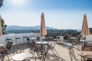 a patio with tables and chairs and umbrellas at Aelia Studios in Koukounaries