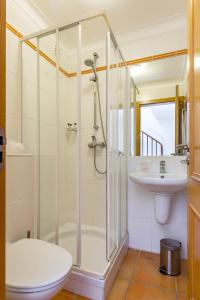 a bathroom with a shower and a toilet and a sink at Pestana Palm Gardens in Carvoeiro