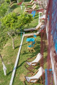 a row of chairs and tables and chairs on the grass at Aelia Studios in Koukounaries